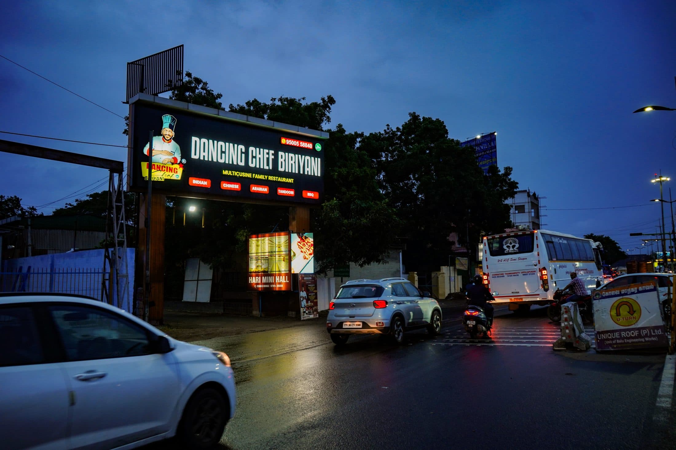Dancing Chef Biriyani restaurant lit up at dusk in Coimbatore